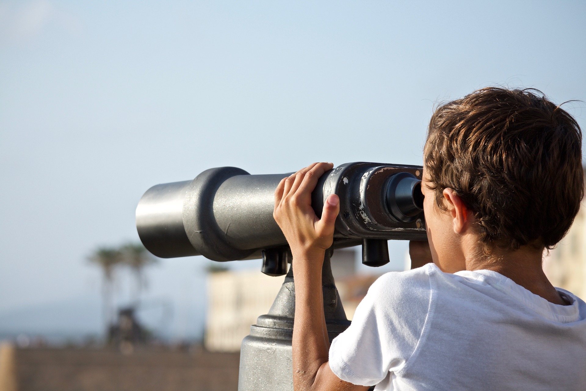 Un ragazzino guarda il panorama con un binocolo